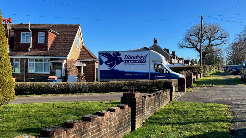 Bluebird stock van leaving house sunny